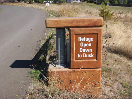 Sign posted on entrance gate - “Refuge Open Dawn to Dusk” Sign posted on entrance gate - “Refuge Open Dawn to Dusk”